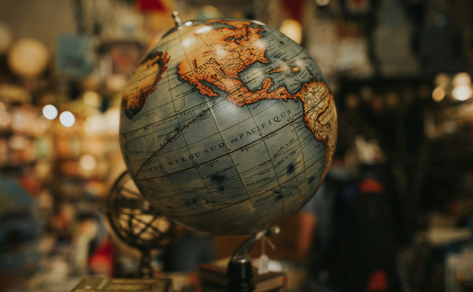 vintage globe sitting on a wooden table with books in the background