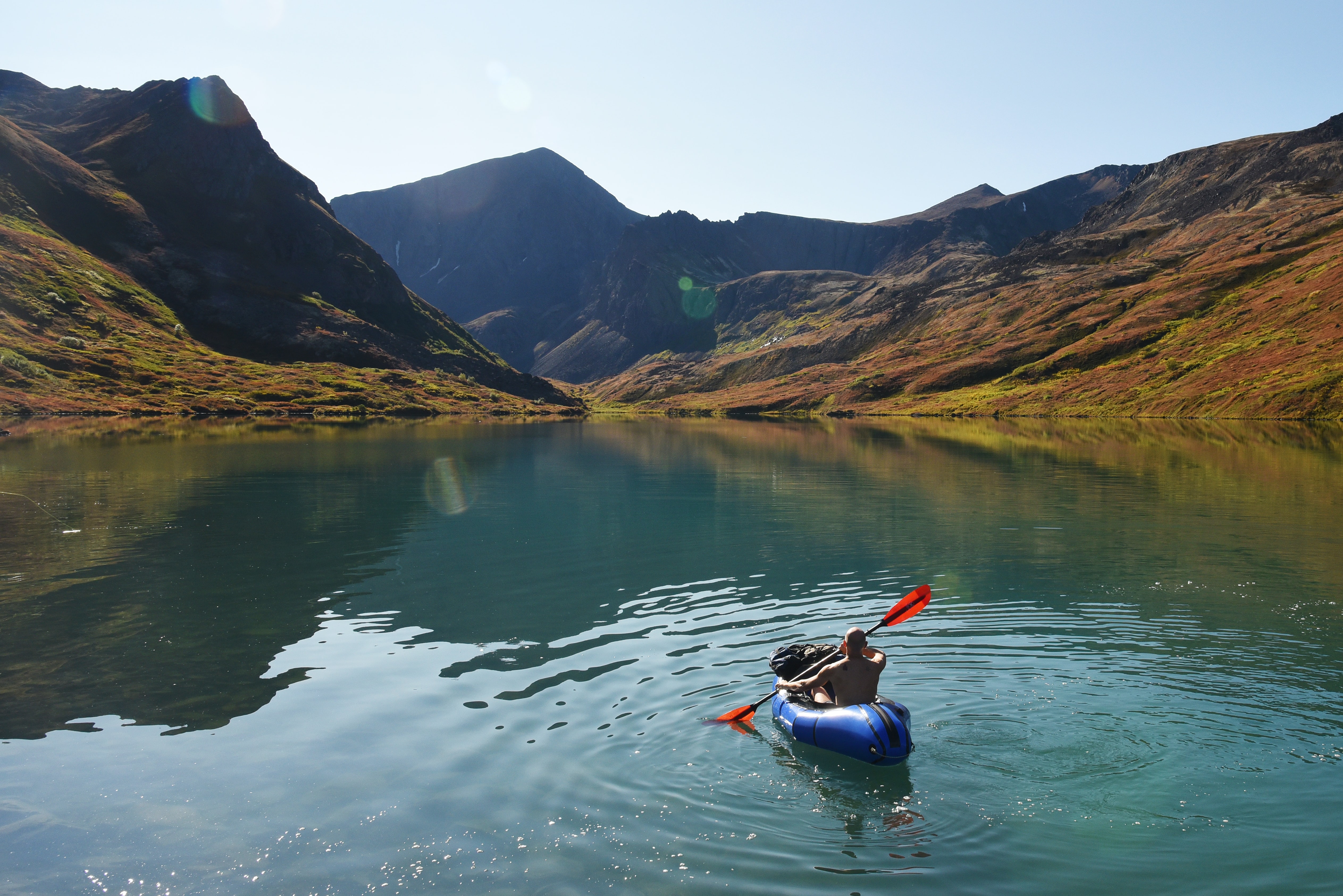 kayaker paddling on a lake in chugach state park in alaska