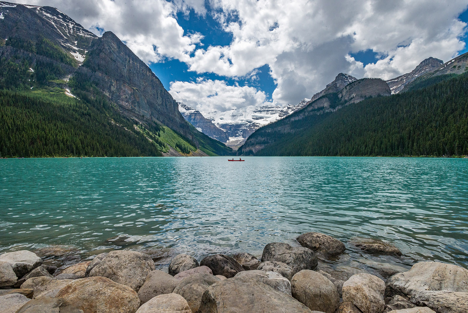turquoise blue lake surrounded by snow-capped mountains