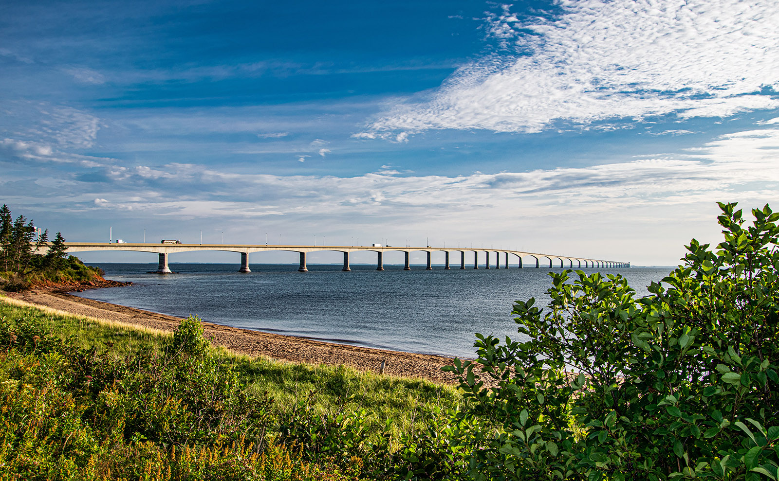 white concrete bridge spanning blue water