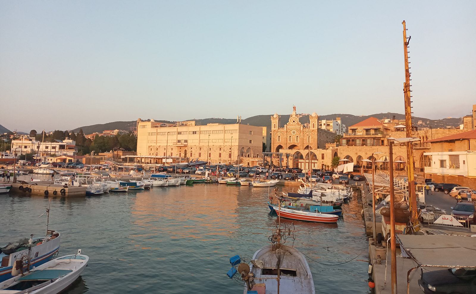boats moored at a stone pier next to the mediterranean sea