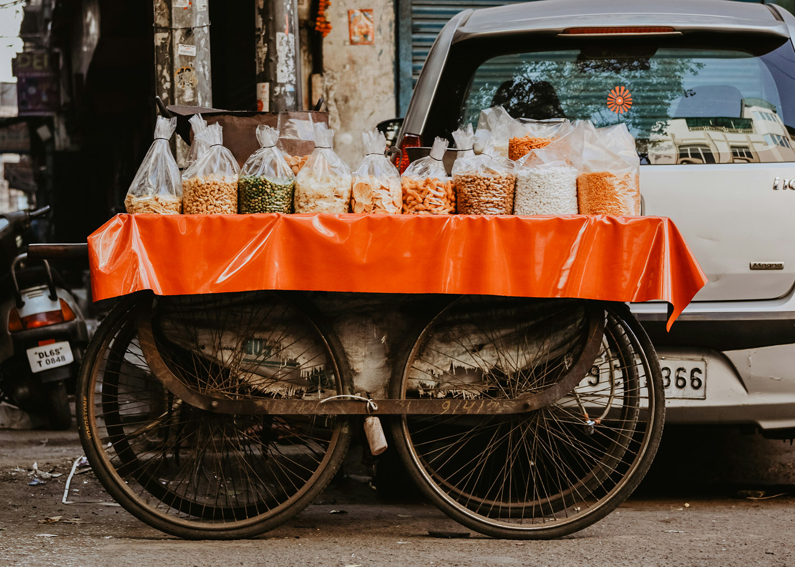 cart on a city street holding bags of multicolored snacks