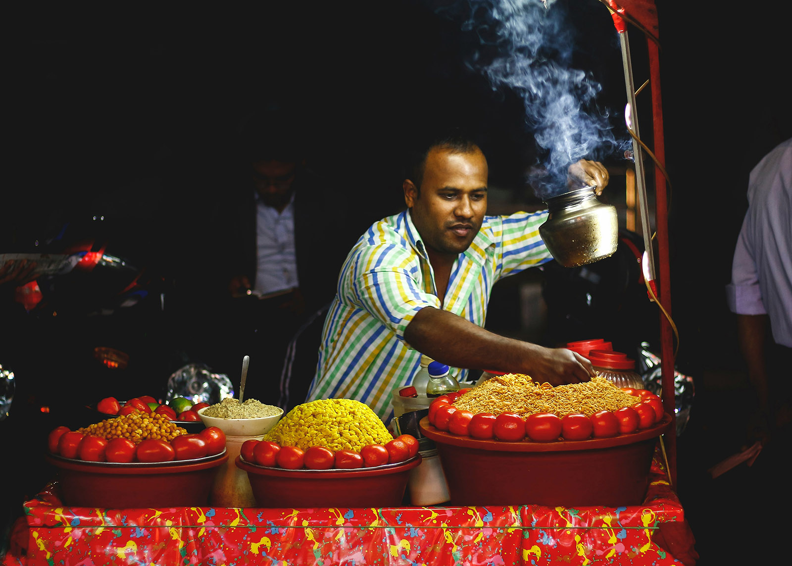 indian man cooking food at a street cart