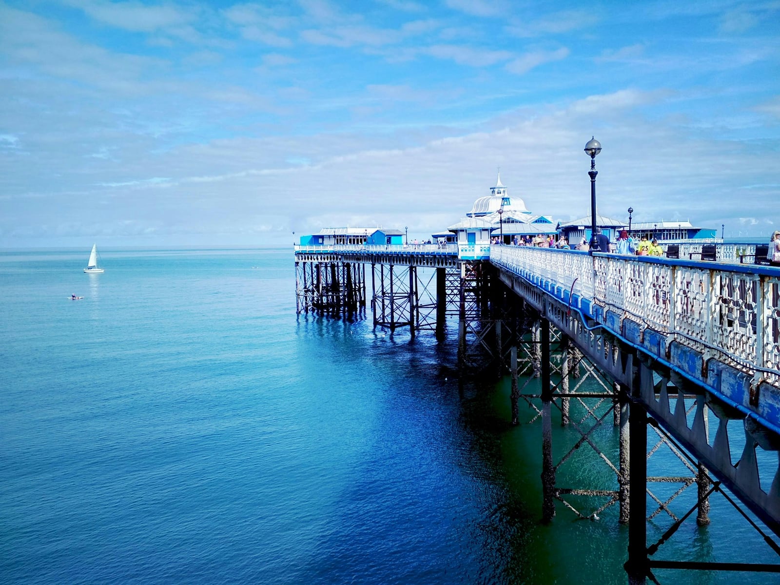 blue and white victorian pier reaching out into the ocean