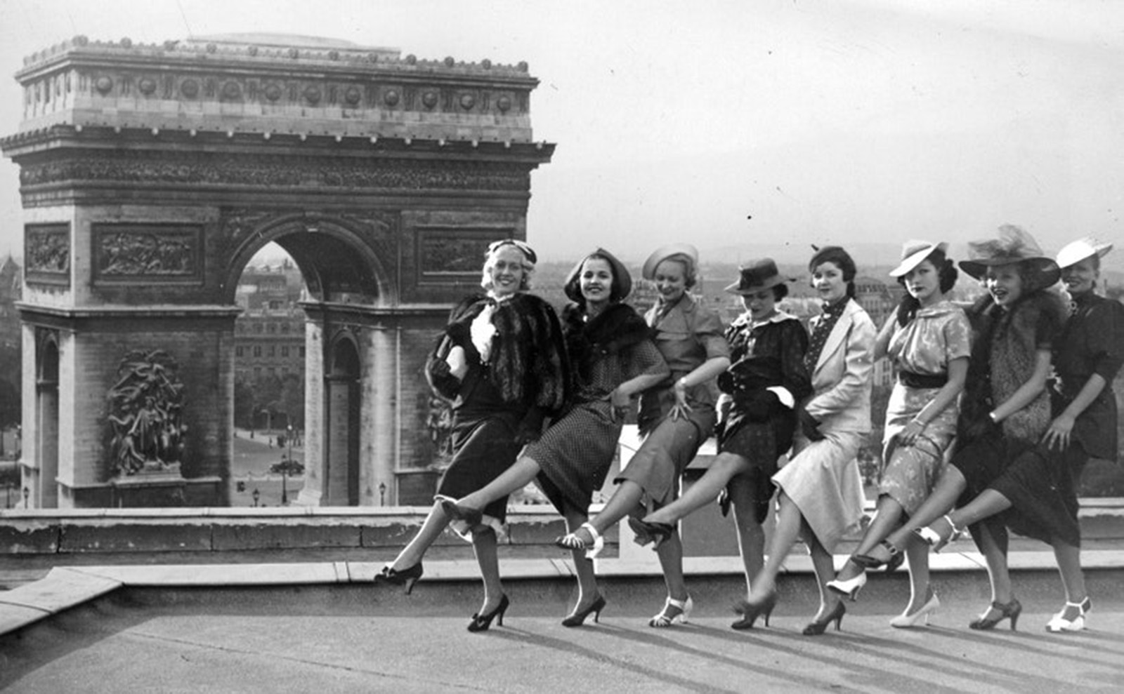 young women posing in front of the arc de triomphe in 1936