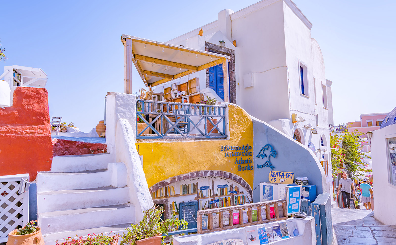 the blue, white, and yellow facade of atlantis books in santorini