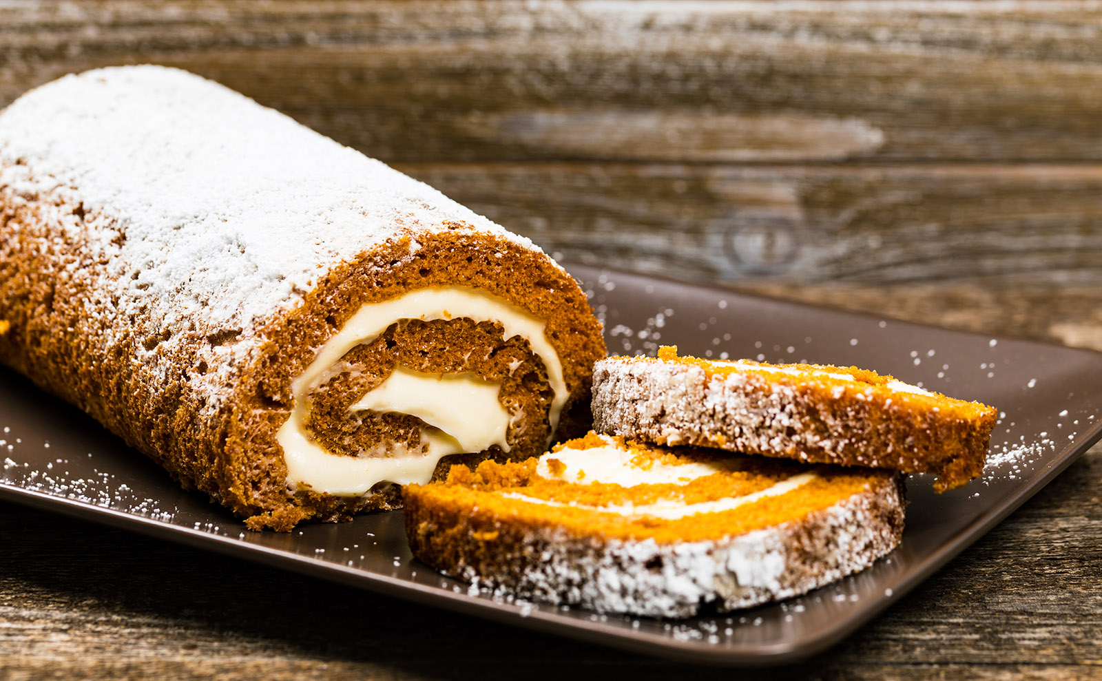 pumpkin cake roll on a wooden plate