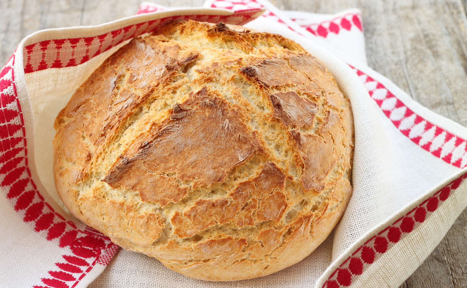 loaf of irish soda bread wrapped in a dish towel