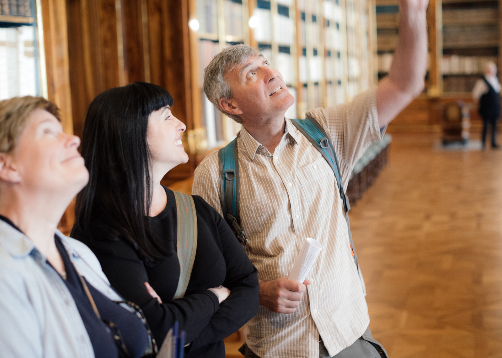 three people looking up at the ceiling frescoes