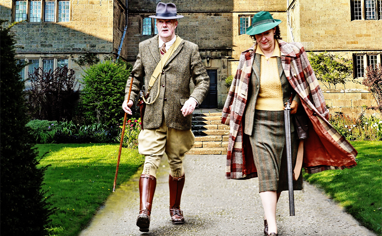 a man and woman wearing tweed suits walking out of an english manor house