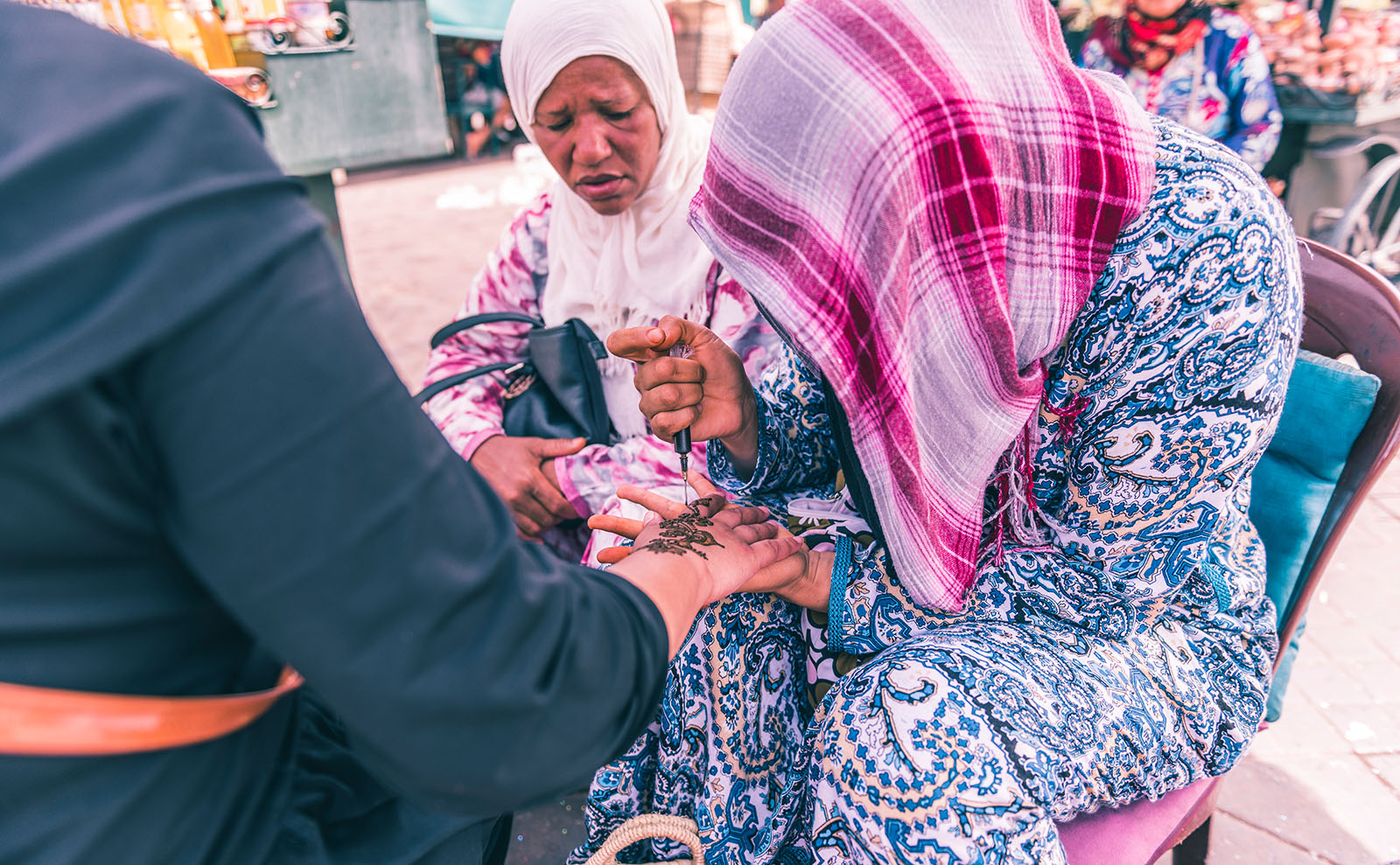 moroccan artist drawing a henna tattoo on a hand
