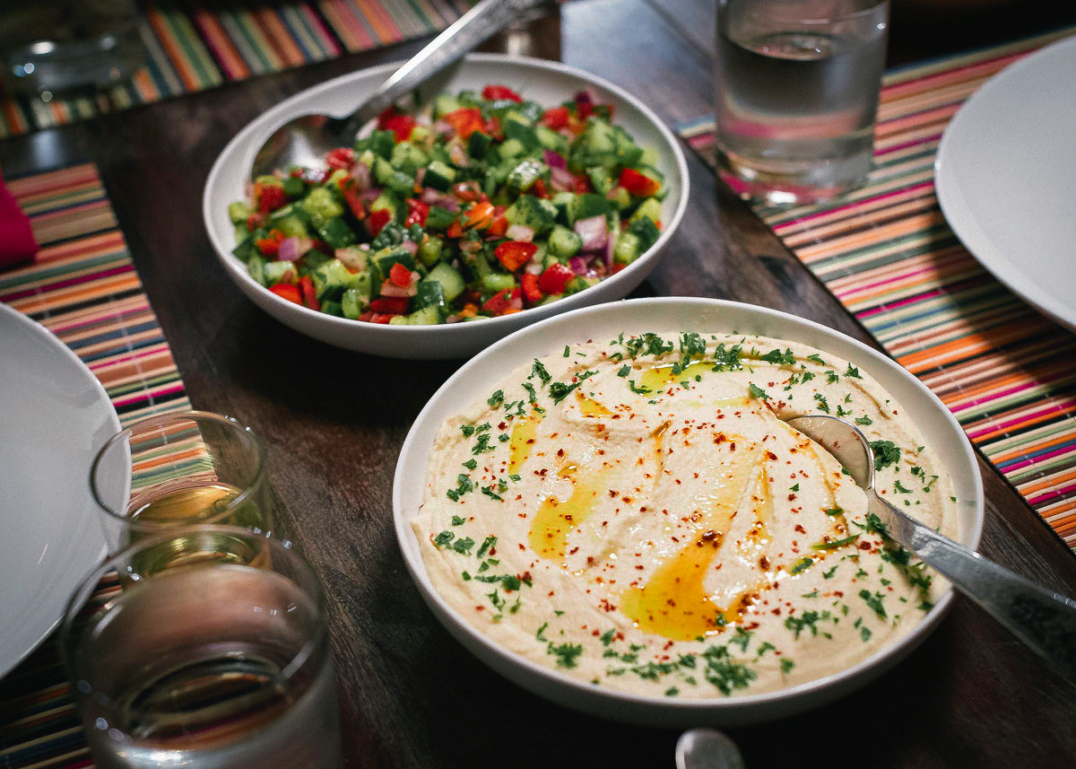 hummus and chopped salad in bowls on a wooden table
