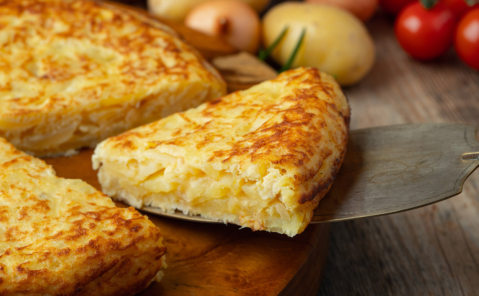 close up of a wedge of a potato omelet on a white plate