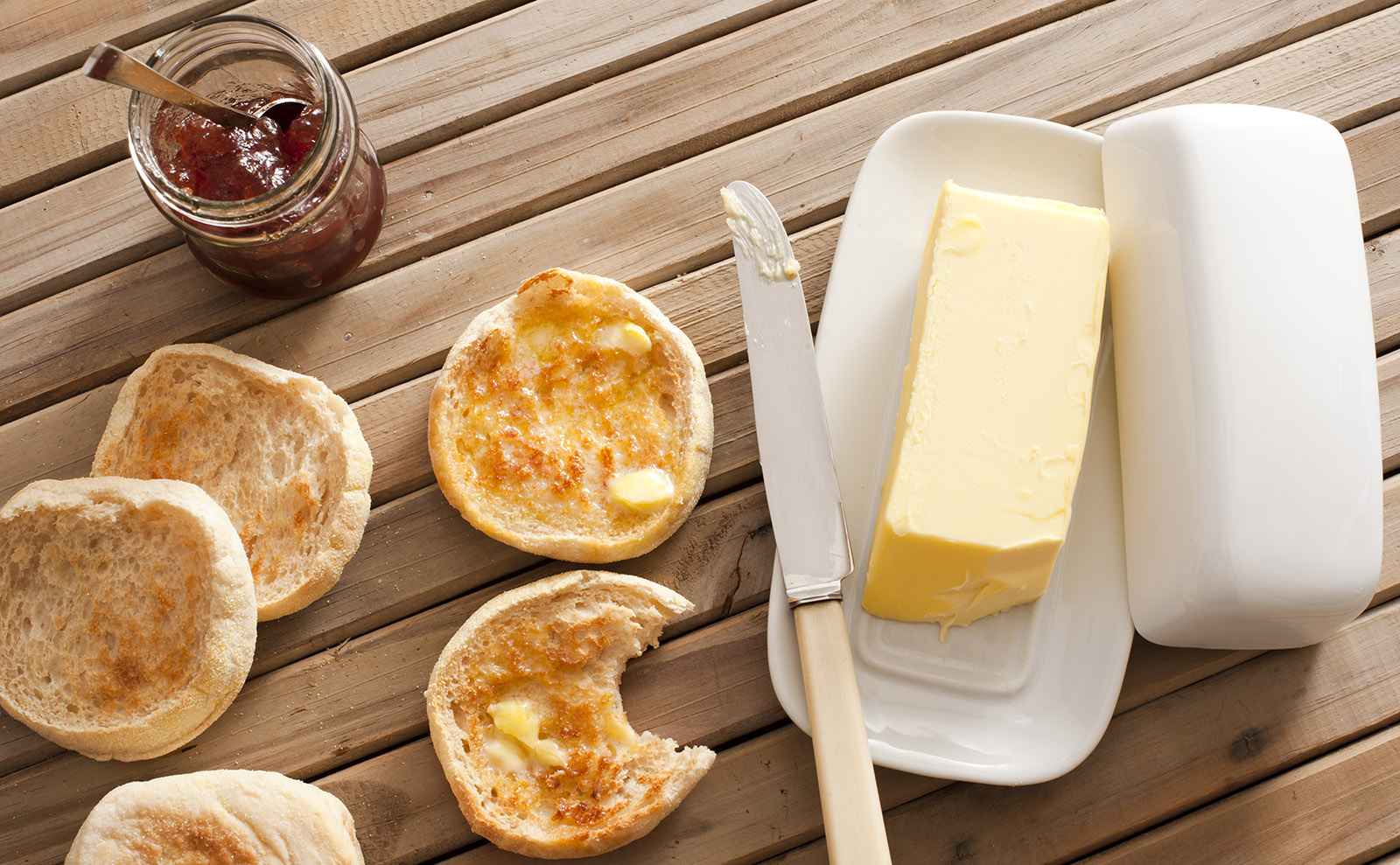 buttered english muffins on a wooden table