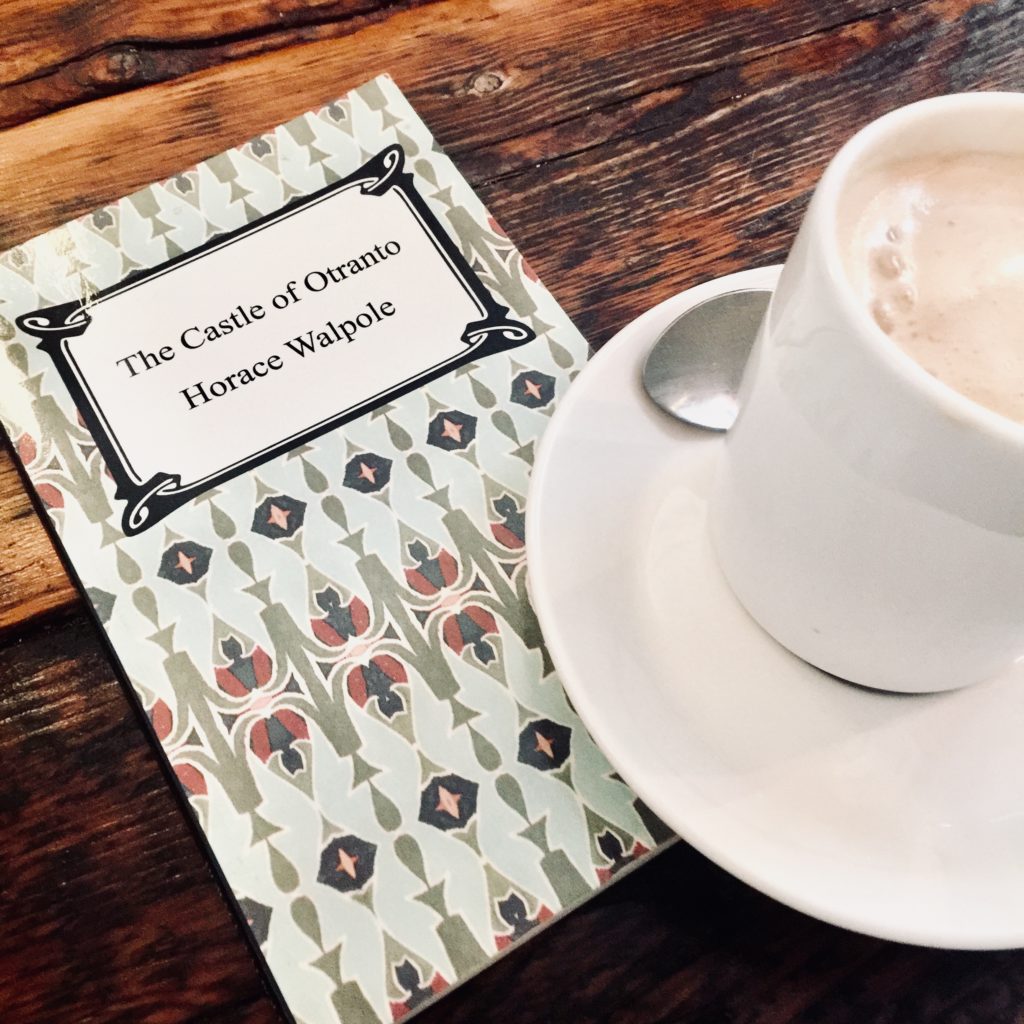 the book The Castle of Otranto with a cup of coffee